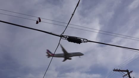 A-nice-low-angle-of-tennis-shoes-on-a-line-as-a-FedEx-plane-lands-in-Southern-California-1