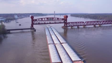 Eine-Schöne-Antenne-Eines-Lastkahns,-Der-Unter-Einer-Stahlzugbrücke-Auf-Dem-Mississippi-Fährt-1