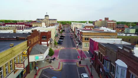 A-lovely-aerial-over-a-Main-Street-in-small-town-USA-ends-with-two-kids-skateboarding-down-the-empty-boulevard