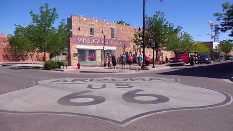 Establishing-shot-of-downtown-Winslow-Arizona-with-mural-depicting-a-flatbed-Ford-and-Route-66-sign