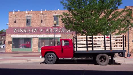 Establishing-shot-of-downtown-Winslow-Arizona-with-mural-depicting-a-flatbed-Ford-on-Route-66