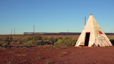 An-Amtrak-train-travels-fast-past-an-American-Indian-teepee-in-the-desert-southwest
