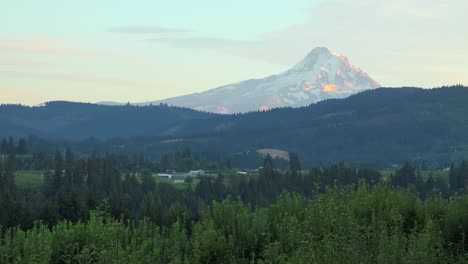 Sunset-light-on-Mt-Hood-near-Hood-River-Oregon-with-farms-and-fields-foreground
