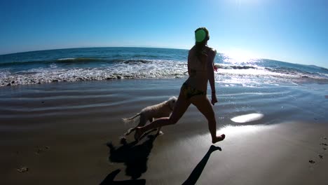 A-girl-runs-with-her-dog-on-the-beach-in-slow-motion