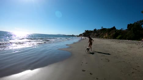 A-girl-runs-with-her-dog-on-the-beach-in-slow-motion-1