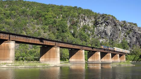 A-freight-train-travels-over-a-bridge-loaded-with-cargo-in-West-Virginia