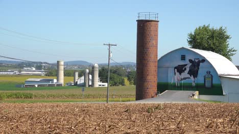 Establecimiento-De-Tiro-De-Una-Granja-Lechera-Con-Gran-Vaca-Pintada-En-El-Granero