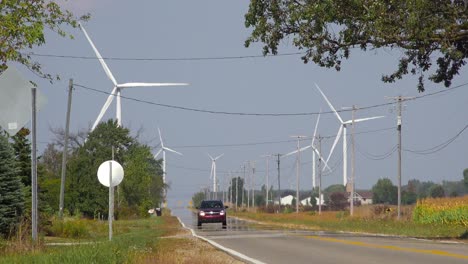 Autos-Fahren-Auf-Einer-Autobahn-In-Der-Nähe-Eines-Riesigen-Windturbinenparks,-Der-Alternative-Energie-Erzeugt