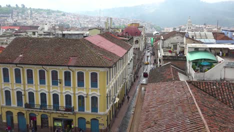 Establishing-shot-across-the-rooftops-of-Quito-Ecuador-with-busy-streets-and-pedestrians