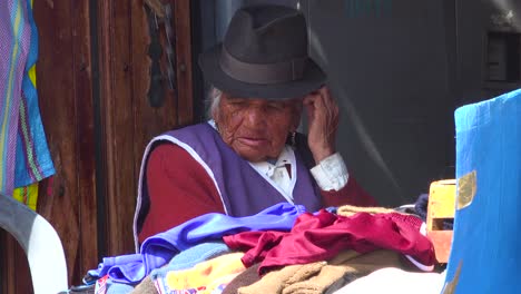 Eine-Bunte-ältere-Einheimische-Frau-Sitzt-In-Einem-Shop-In-Quito-Ecuador