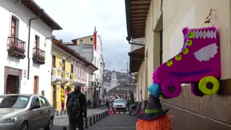 Pedestrians-walk-on-the-cobblestone-streets-of-Quito-Ecuador-with-pinata-foreground