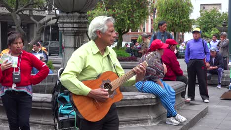 A-man-plays-guitar-in-a-park-in-downtown-Quito-Ecuador-udring-lunch-hour