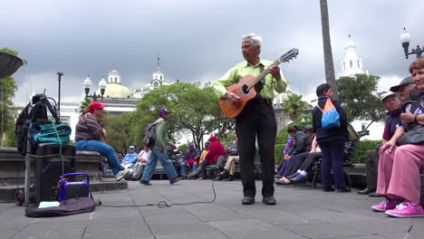 A-man-plays-guitar-in-a-park-in-downtown-Quito-Ecuador-udring-lunch-hour-1