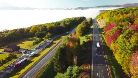 Aerial-of-a-semi-truck-traveling-on-a-highway-road-through-the-fog-in-fall