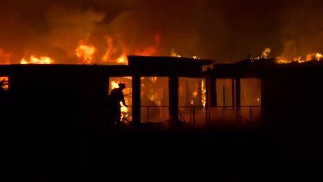 Firefighters-pour-water-on-a-burning-home-at-night-during-the-2017-Thomas-fire-in-Ventura-County-California
