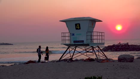A-sunset-behind-a-lifeguard-station-along-a-California-beach-1