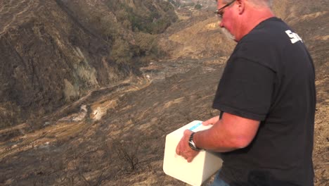 A-man-rolls-block-fo-salt-into-a-burned-canyon-to-help-feed-wildlife-displaced-by-the-Thomas-wildfire-in-2017