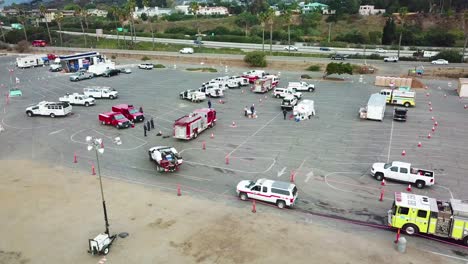High-angle-pan-of-firefighters-in-fire-trucks-lining-up-for-duty-at-a-staging-area-during-the-Thomas-Fire-in-Ventura-California-in-2017