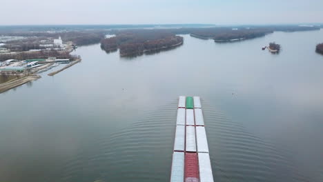 Aerial-of-a-coal-barge-pushed-by-tugboat-moving-up-the-Mississippi-River-near-Burlington-Iowa-with-suspension-bridge-foreground-1