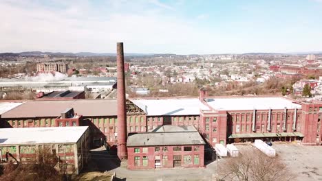 Aerial-over-an-abandoned-American-factory-with-smokestack-near-Reading-Pennsylvania