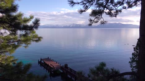 Pretty-panning-shot-of-the-shores-of-Lake-Tahoe-Nevada-with-Sierras-and-pier