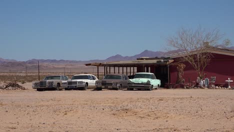 Old-classic-Cadillac-cars-and-other-vintage-automobiles-sit-outside-a-remote-ranch-house-in-the-Mojave-Desert