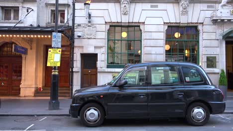 A-London-taxi-cab-is-parked-outside-a-restaurant-or-pub