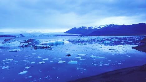 Atemberaubende-Drohnen-Luftaufnahmen-über-Eisbergen-In-Einer-Gletscherbucht-Deuten-Auf-Eine-Globale-Erwärmung-In-Der-Arktis-Bei-Der-Jökulsarlon-Gletscherlagune-Island-Nacht-Hin
