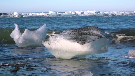 Icebergs-sit-on-black-sand-Diamond-Beach-Jokulsarlon-in-the-Arctic-Iceland-polished-and-glistening-like-jewels