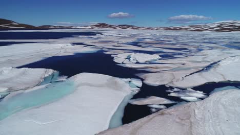 Antenne-über-Einem-Hochgebirgssee-Mit-Großen-Schmelzenden-Eisschilden-und-Eisbergen-In-Island