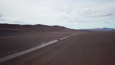Very-good-aerial-of-a-black-van-traveling-on-a-dirt-road-across-the-highland-interior-of-Iceland-2