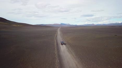 Very-good-aerial-of-a-black-van-traveling-on-a-dirt-road-across-the-highland-interior-of-Iceland-4