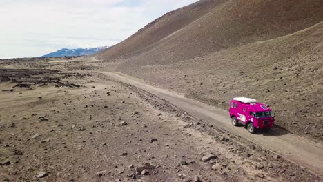 Aerial-of-a-rare-pink-Land-Rover-101-driving-through-the-outback-highlands-of-desolate-Iceland-1