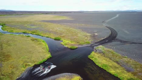 Aerial-over-a-black-van-driving-through-a-river-in-the-highlands-of-Iceland-1