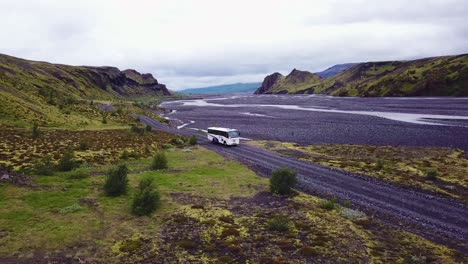 Aerial-over-a-bus-driving-beside-a-river-in-the-highlands-of-Iceland-1