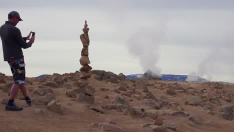 Un-Hombre-Apila-Piedras-De-Equilibrio-De-Rocas-Cerca-De-Una-Zona-Geotérmica-En-Islandia