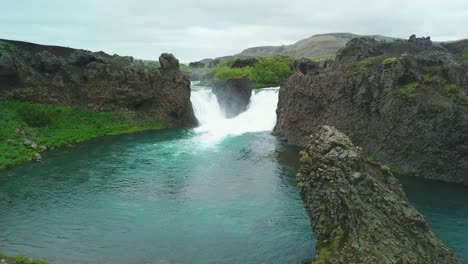 Aerial-over-the-Hjalparfoss-waterfall-in-Iceland-1