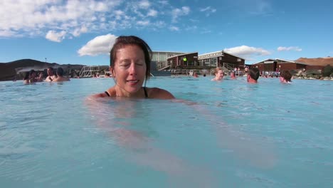 A-woman-swims-in-a-geothermal-pool-at-a-day-spa-in-Iceland
