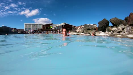 A-man-and-woman-swim-in-a-geothermal-pool-at-a-day-spa-in-Iceland-1