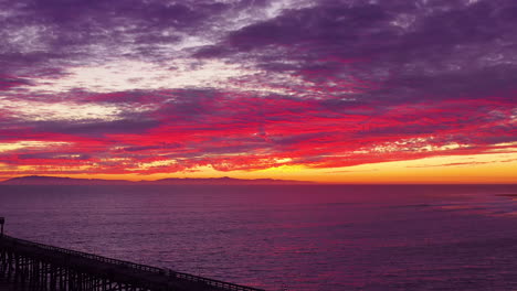 An-astonishing-sunset-aerial-shot-over-a-long-pier-and-the-Pacific-Ocean-and-Channel-Islands-in-Ventura-Southern-California-1