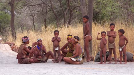 African-San-bushmen-women-children-and-tribal-natives-sit-in-a-circle-chanting-singing-and-clapping-in-a-small-village-in-Namibia
