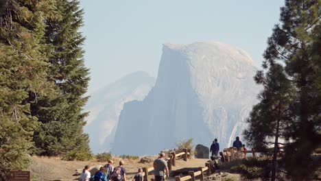 Tourists-at-a-Glacier-Point-vista-in-Yosemite-National-Park--Half-Dome-and-the-Sierra-Nevada-Mountains-in-the-distance