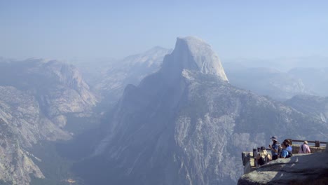 Tourists-at-a-Glacier-Point-vista-in-Yosemite-National-Park--Half-Dome-and-the-Sierra-Nevada-Mountains-in-the-distance-1