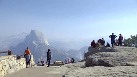 Tourists-at-a-Glacier-Point-vista-in-Yosemite-National-Park--Half-Dome-and-the-Sierra-Nevada-Mountains-in-the-distance-2
