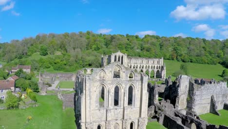 A-rising-reveal-aerial-shot-of-Rievaulx-Abbey-in-England