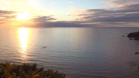Pan-shot-from-setting-sun-to-a-small-Scottish-coastal-fishing-village