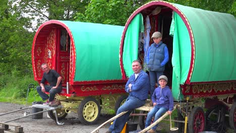 Gypsies-pose-for-a-picture-in-their-wooden-caravans-along-a-roadway-in-England