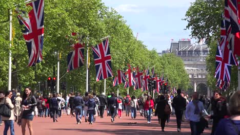 Pedestrians-walk-on-the-Mall-near-Buckingham-Palace-London-with-British-flags-flying