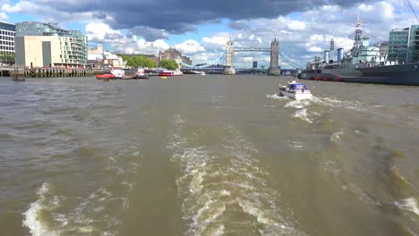 A-POV-shot-along-the-Thames-River-of-the-Tower-of-London-Bridge-in-distance