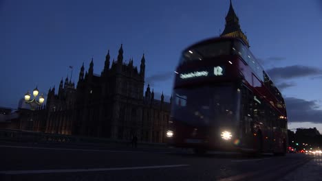 Traffic-passes-in-front-of-Big-Ben-and-Houses-Of-Parliament-in-London-England-at-night